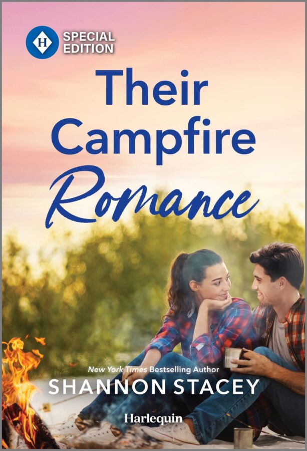 Cover of Their Campfire Romance by Shannon Stacey. A couple, both wearing flannel shirts, are sitting side-by-side next to a campfire. He has short dark hair and she has a long, dark ponytail, and she’s turned to face him with the most adorably romantic smile.
