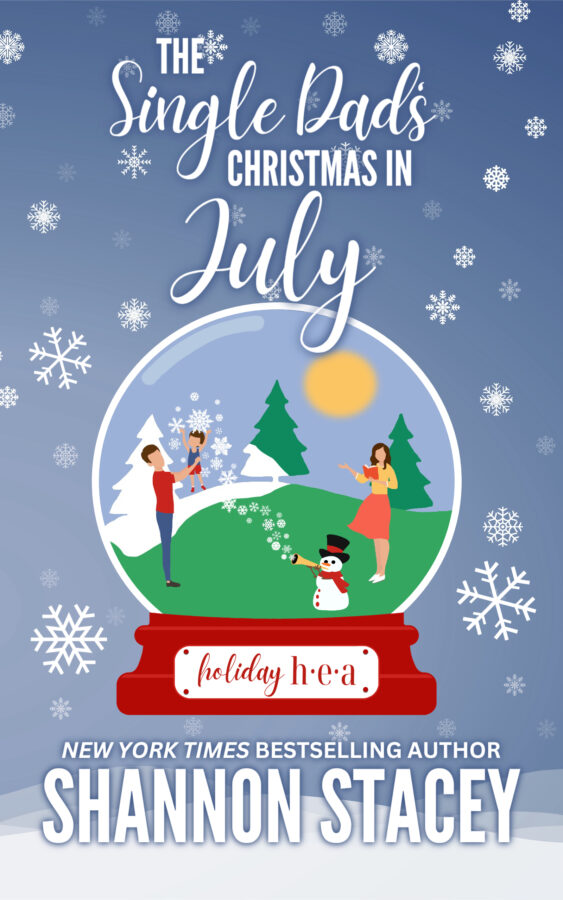 Illustrated cover: The Single Dad’s Christmas in July by Shannon Stacey. An illustrated scene inside of a snow globe surrounded by snowflakes. A woman with dark hair and wearing a summery top and skirt is holding a book in her hand and looking at a dark-haired man in jeans and a T-shirt lifting a dark-haired male toddler wearing shorts and a tank top into the air. Between them in a snowman in top hat and scarf blowing fake snow out of a horn across the summer landscape.